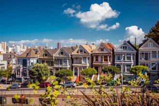 white and brown 2-storey houses with vehicles in front during daytime