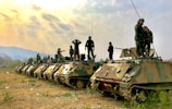 soldiers on top of battle tanks