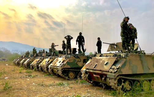 soldiers on top of battle tanks