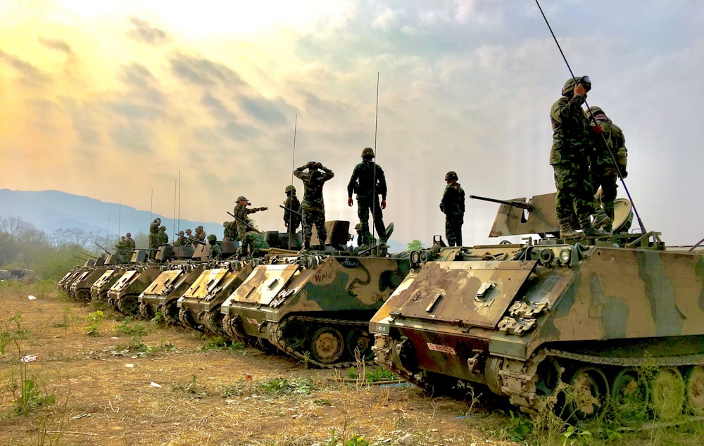 soldiers on top of battle tanks