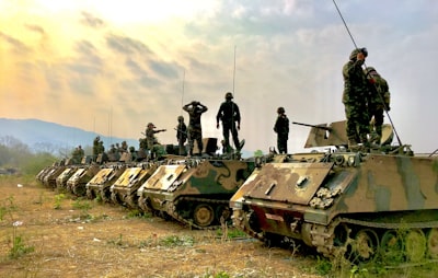 soldiers on top of battle tanks military teams background