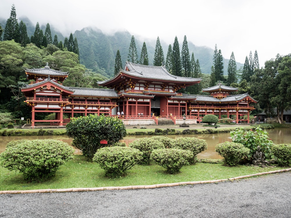 brown and black temple between trees at daytime