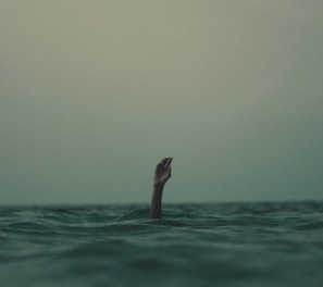 person with hand above water