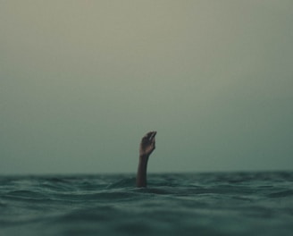 person with hand above water