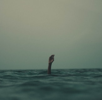 person with hand above water