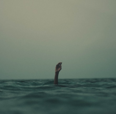 person with hand above water