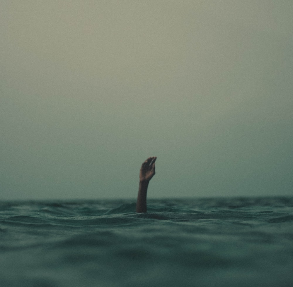 persona con la mano fuera del agua