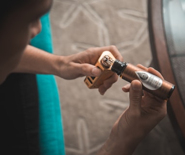 person putting e-juice on gold Wismec variable vaporizer