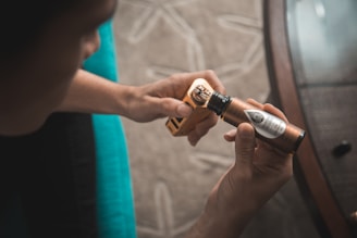 person putting e-juice on gold Wismec variable vaporizer