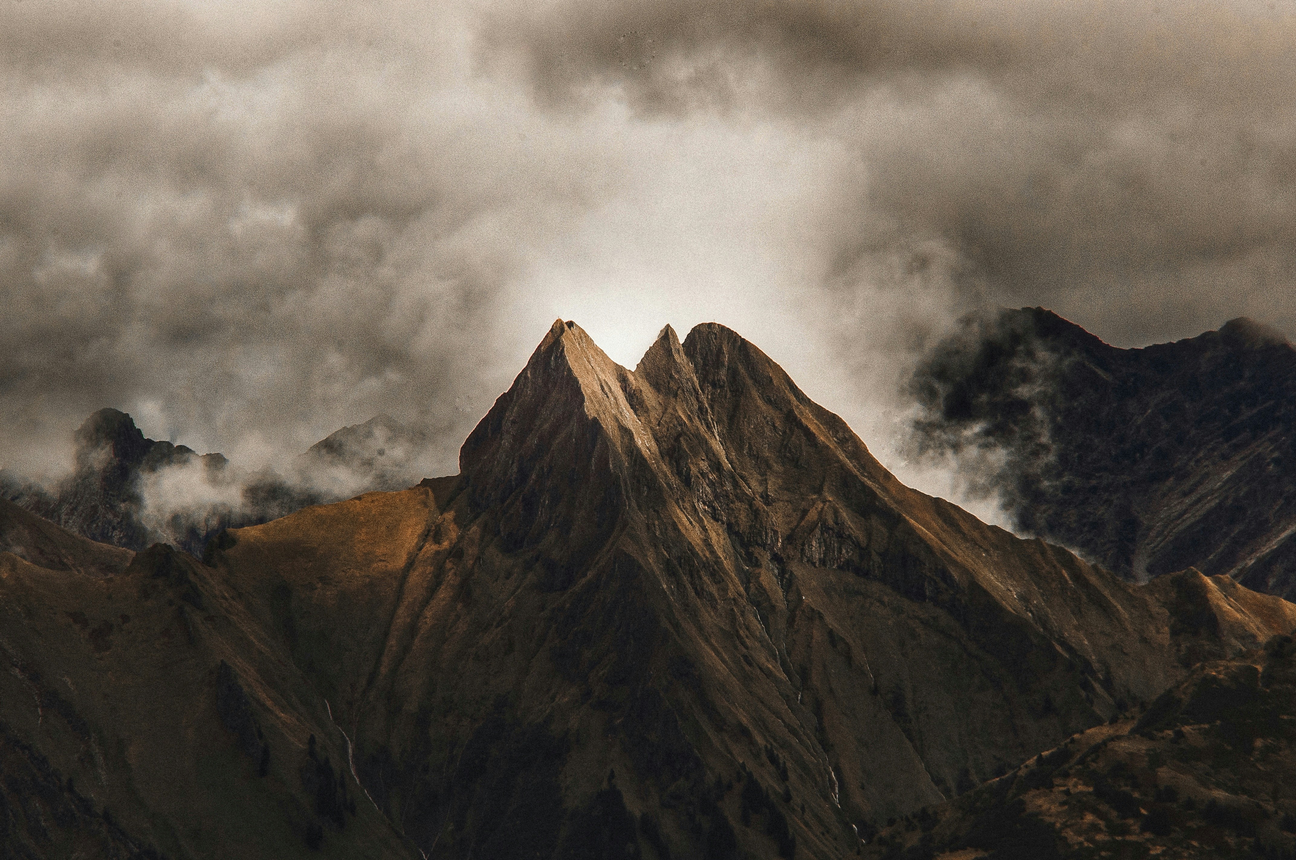 brown mountain with clouds