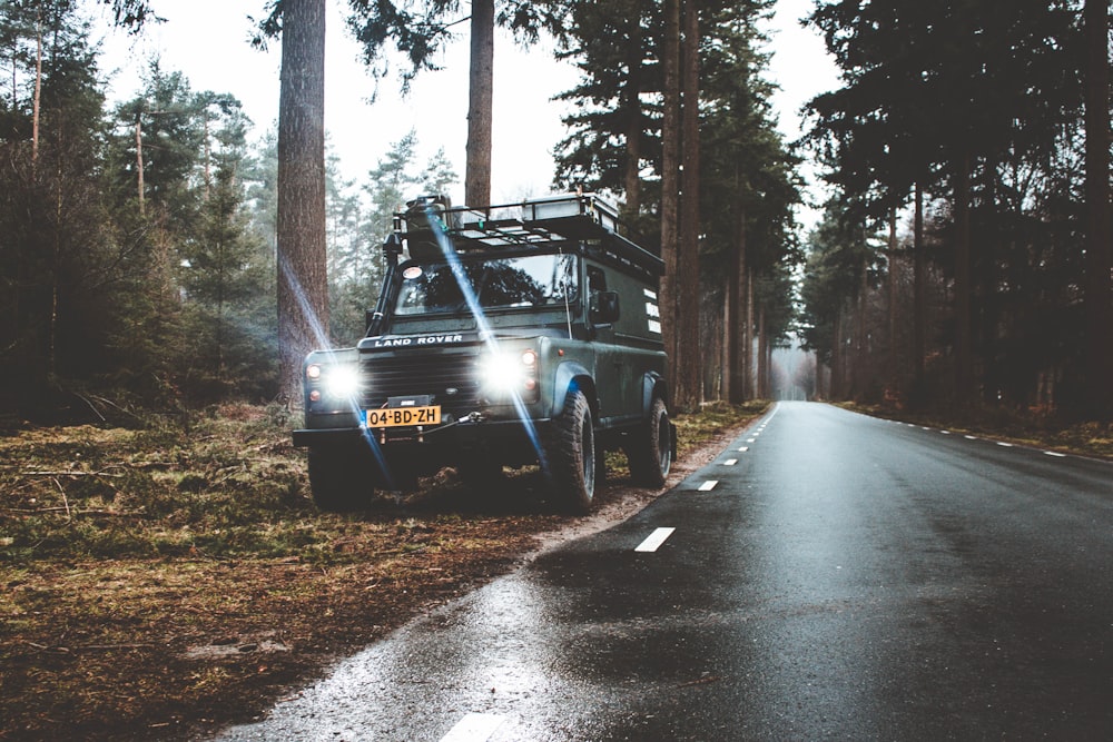 vehicle on side of road with turned on headlights