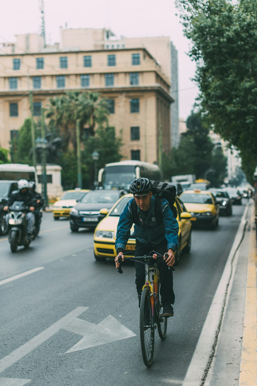 uomo che va in bicicletta su una strada con automobili durante il giorno