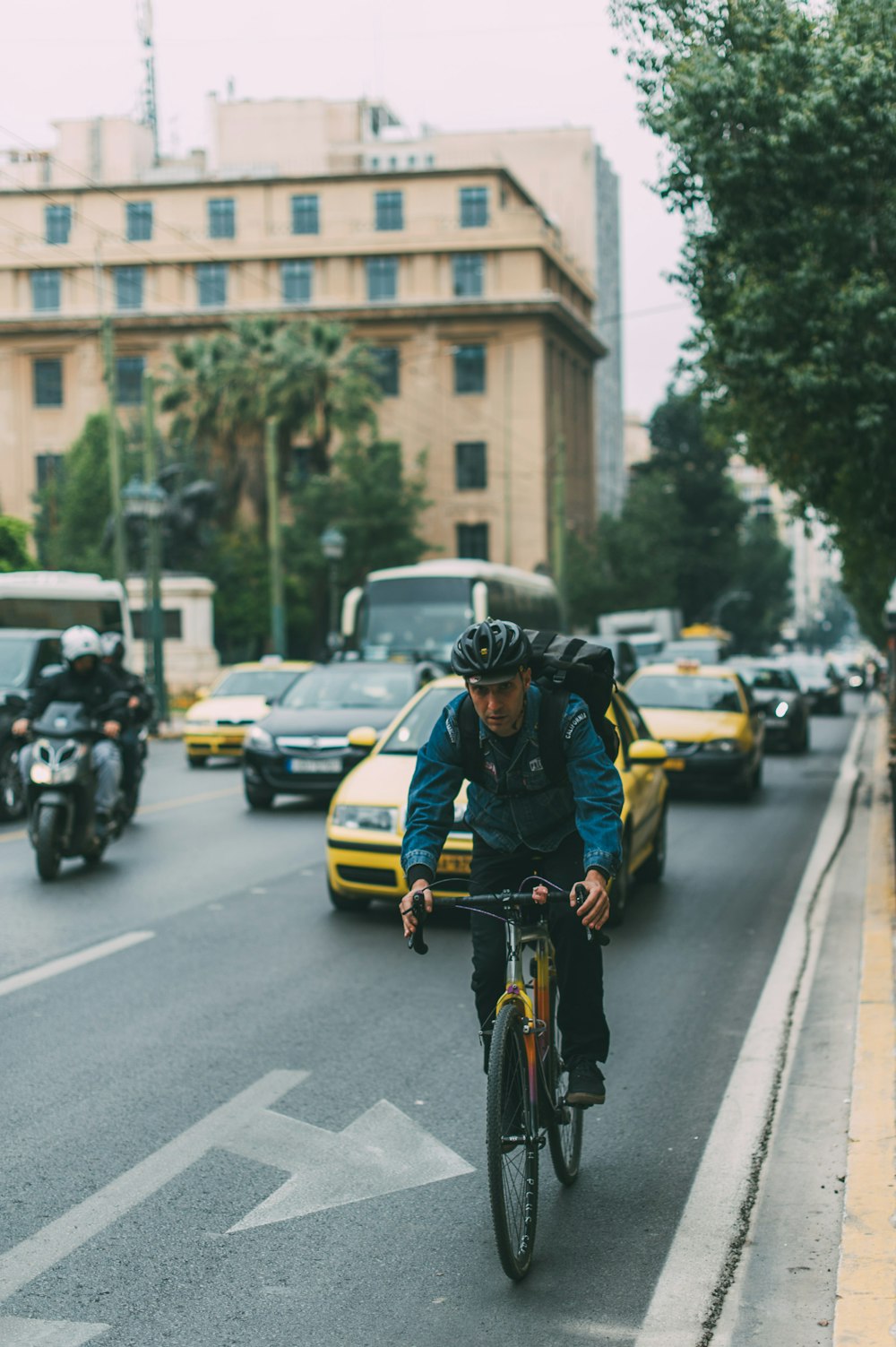 Mann fährt tagsüber Fahrrad auf einer Straße mit Autos