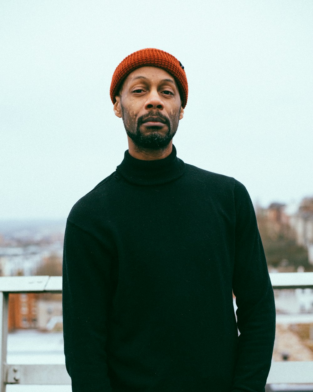 man wearing black sweater and red knitted cap