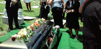 Team member gently assisting family with delicate paperwork at funeral home.