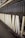 A row of large, vertical spinning spindles, likely part of a textile or yarn production machine. The spindles are light-colored and arranged neatly along a metal framework.
