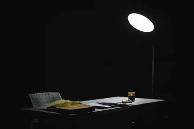 A professional cleaner carefully wiping down an office desk after hours with soft lighting highlighting the cleanliness.