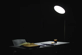 A dimly lit detective's desk scattered with clues, maps, and a magnifying glass.