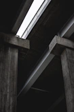 A dramatic warehouse shot showcasing towering stacks of heavy steel beams under cinematic lighting with gold accents