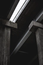 A dramatic warehouse shot showcasing towering stacks of heavy steel beams under cinematic lighting with gold accents