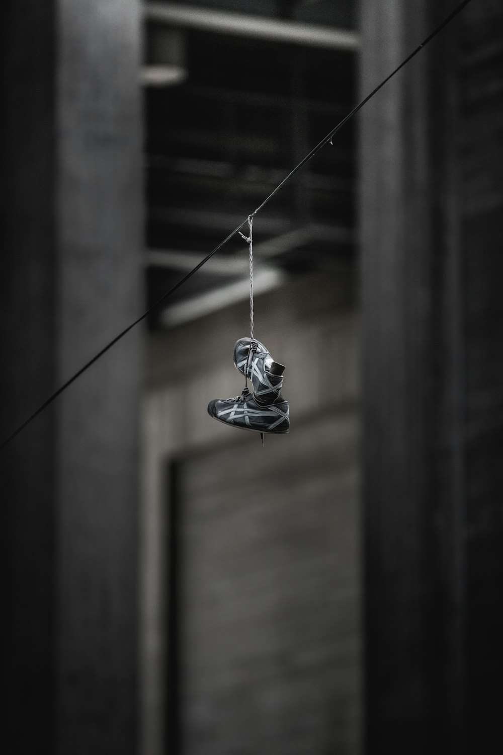 pair of black-and-gray ASICS shoes hanging on wire
