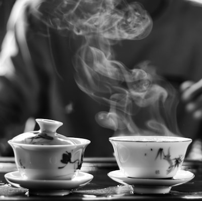 An elegant tea cup with steam rising, set against a navy blue background.