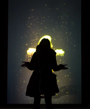 Abstract human silhouette made of glowing particles against a deep navy background.