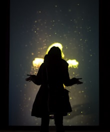 Visual of a user interacting with glowing, translucent creatures layered over a city park scene.