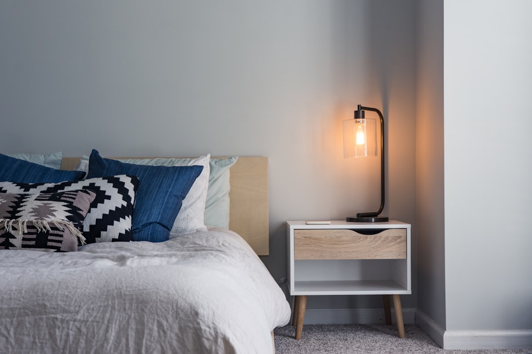  black table lamp on nightstand single bed