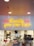 Neon sign in yellow text reading 'Quality you can taste' is mounted on a white tiled wall inside a fast food restaurant. Beneath the sign, several workers dressed in white uniforms and red hats are busy at a counter preparing food.