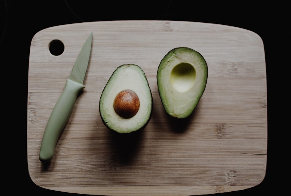 Avocats tranchés sur une planche à découper en bois brun dans la photographie de vue de dessus