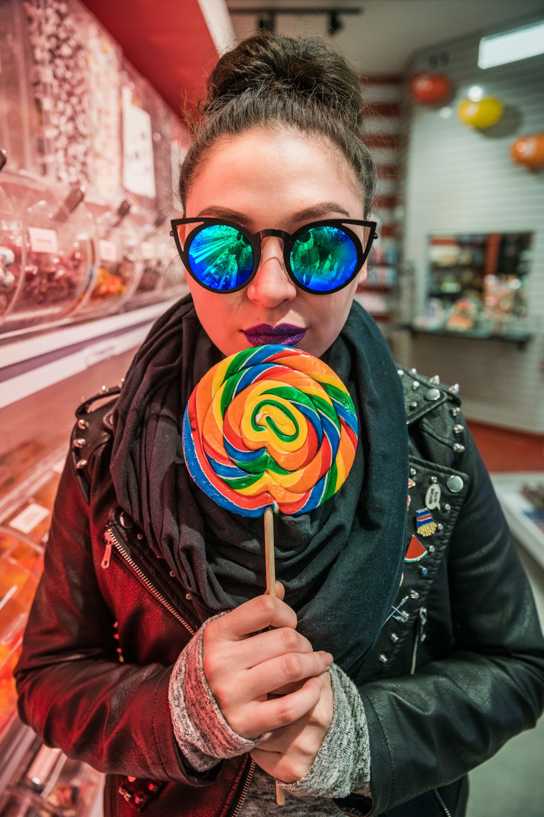 woman holding multicolored lollipop