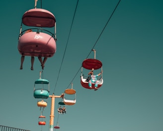 people on assorted-color cable cars at daytime