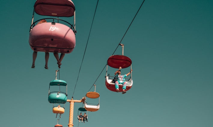 people on assorted-color cable cars at daytime