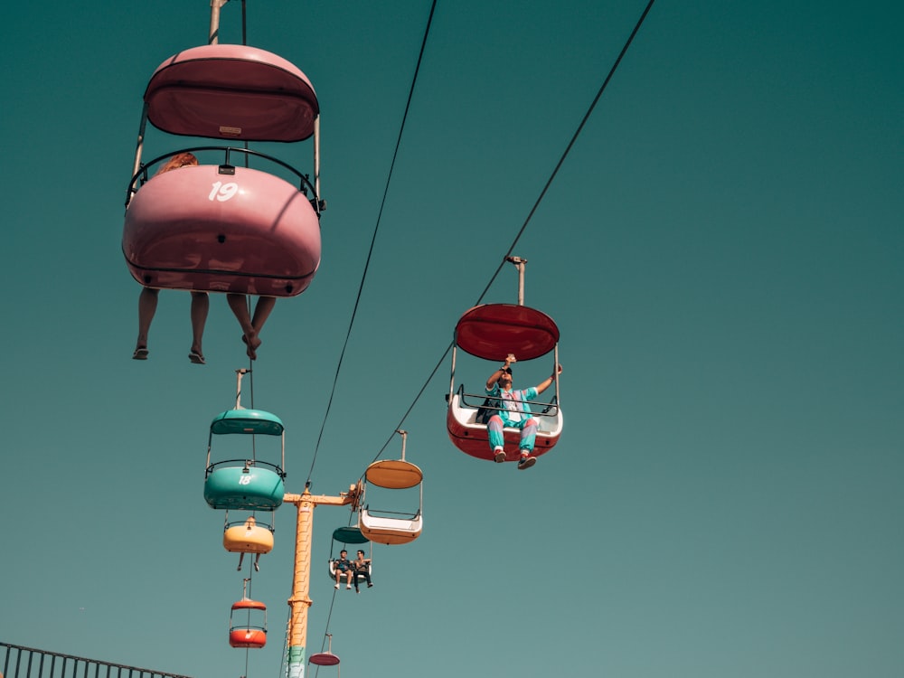 people on assorted-color cable cars at daytime