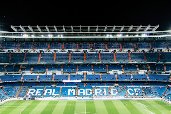 The Santiago Bernabéu Stadium with blue seats and Real Madrid CF lettering at night