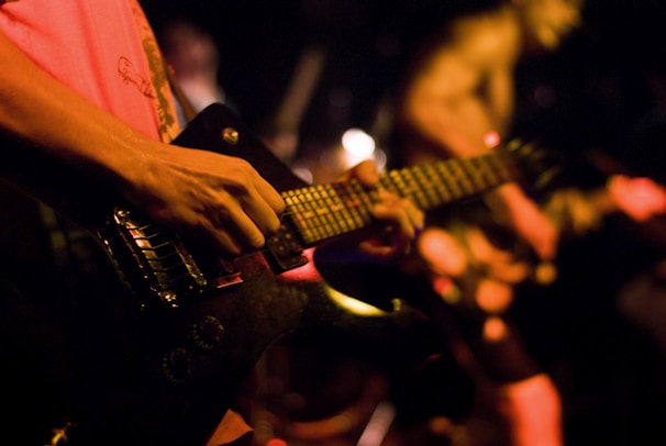 Close-up of a guitar player passionately strumming during a concert.