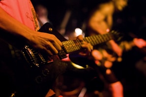 Close-up of a child strumming an electric guitar with focused excitement.