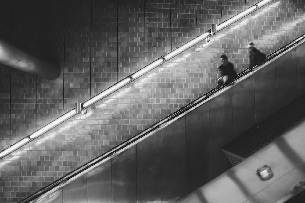 man and woman standing on scalator