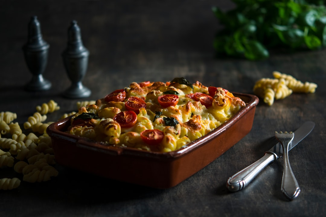 bake mac on brown ceramic bowl beside fork and knife