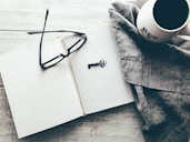 eyeglasses and skeleton key on white book