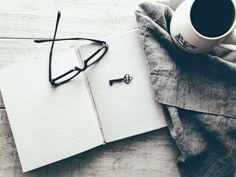 eyeglasses and skeleton key on white book