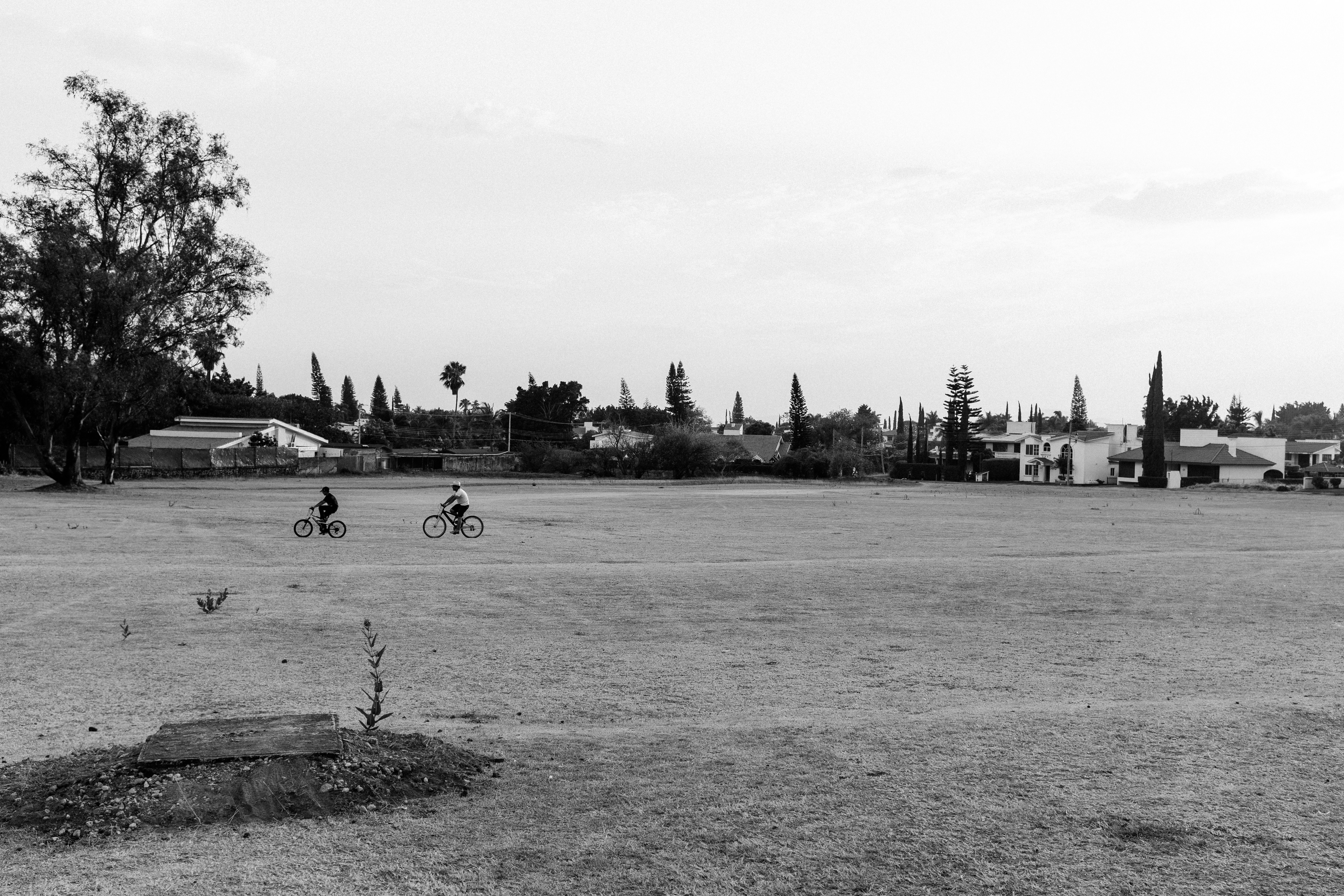 Two guys biking on a field