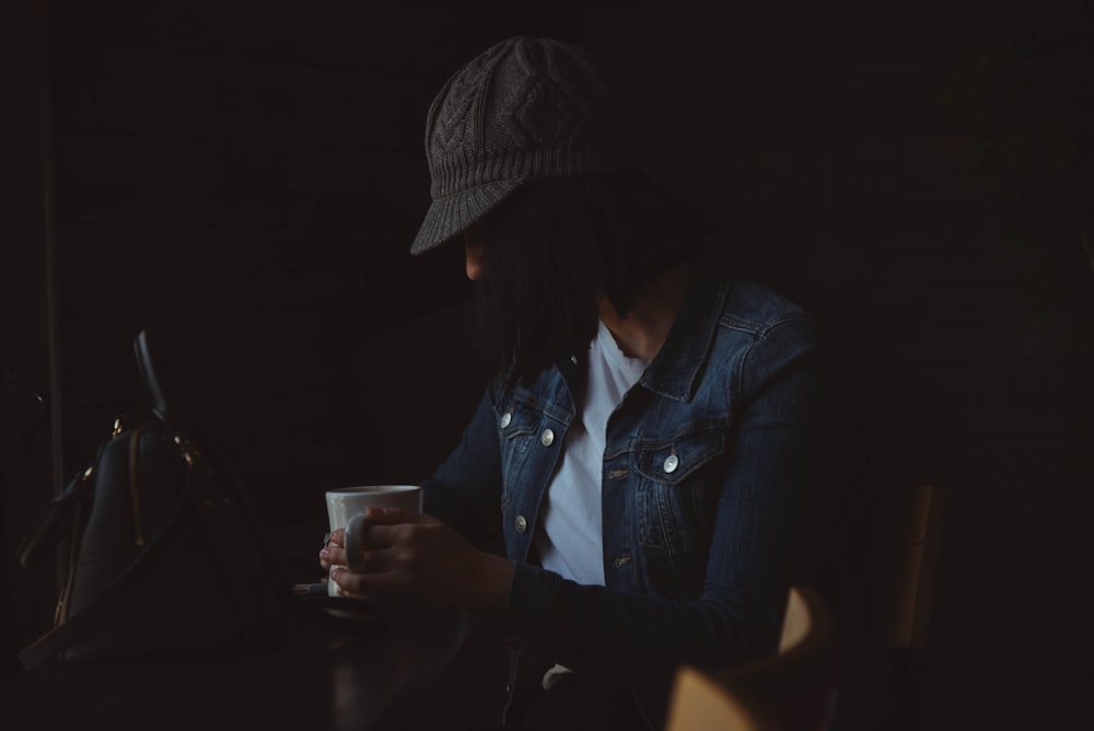 person sitting while holding mug