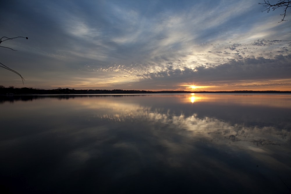 photo of body of water with sky reflection
