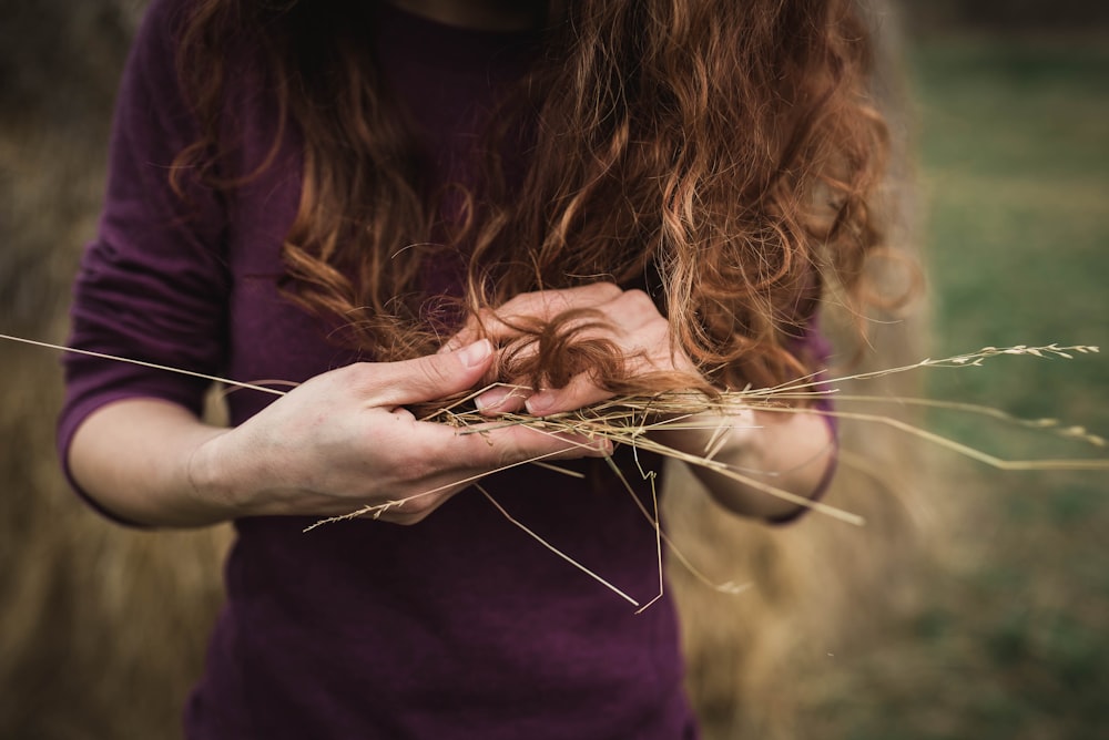 femme tenant des cordes d’herbe