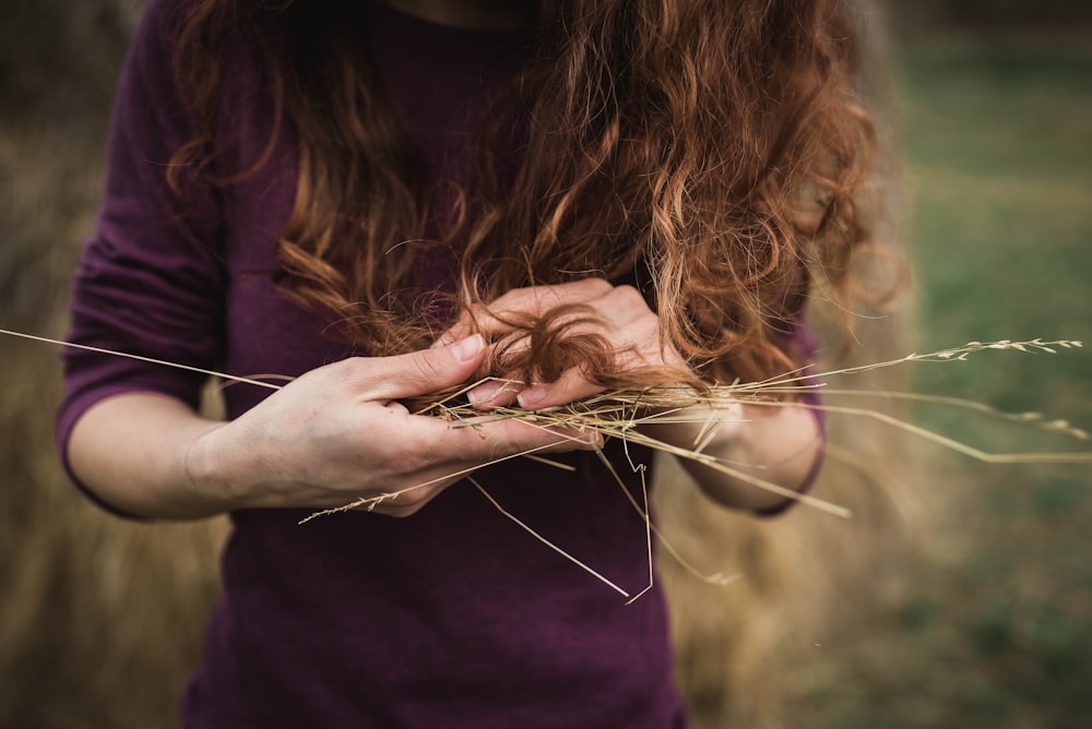 woman holding grass strings