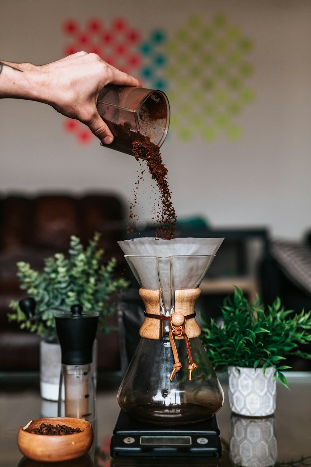 Person, die im Begriff ist, Kaffeepulver in die Kaffeemaschine zu gießen