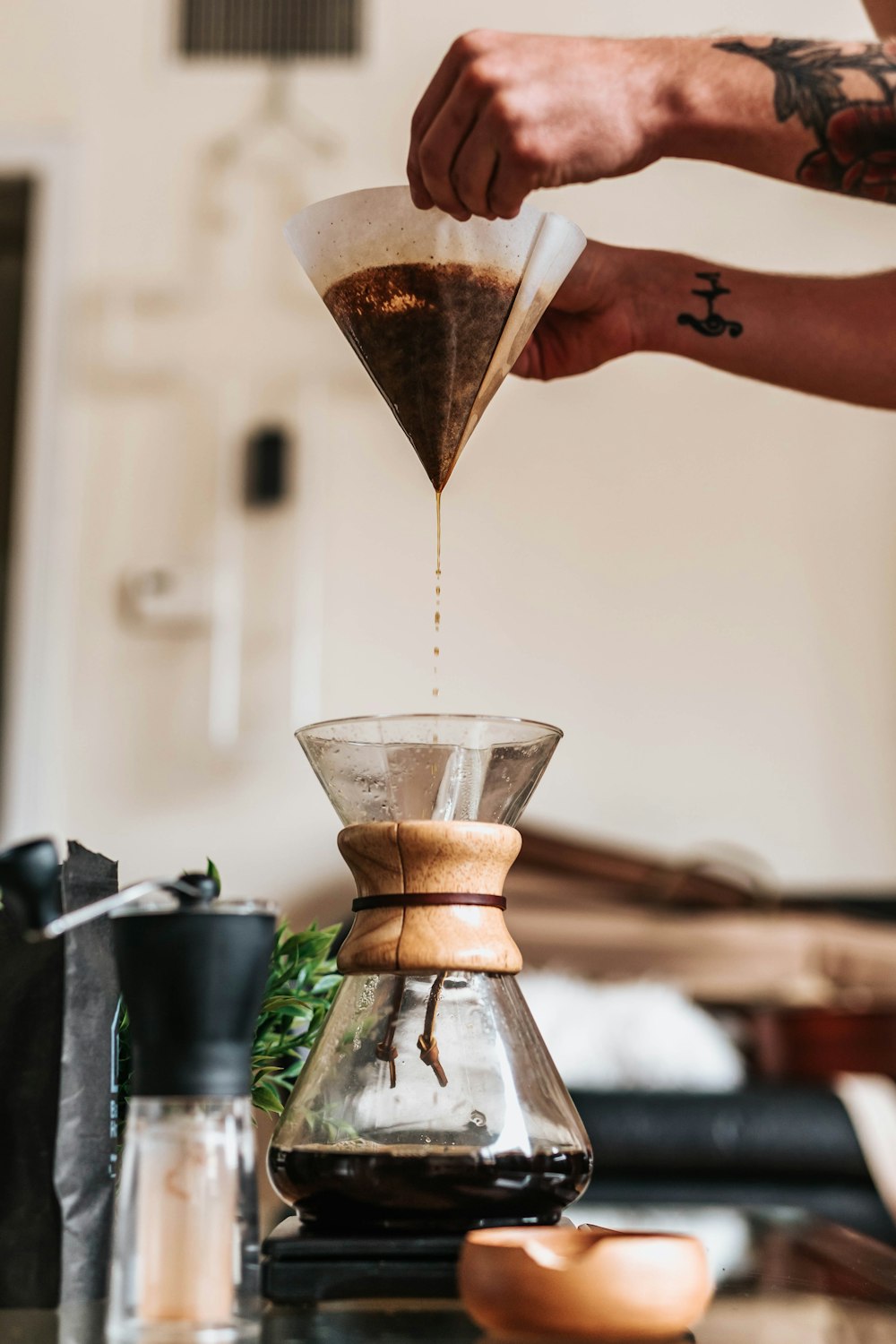 person filtering coffee in funnel