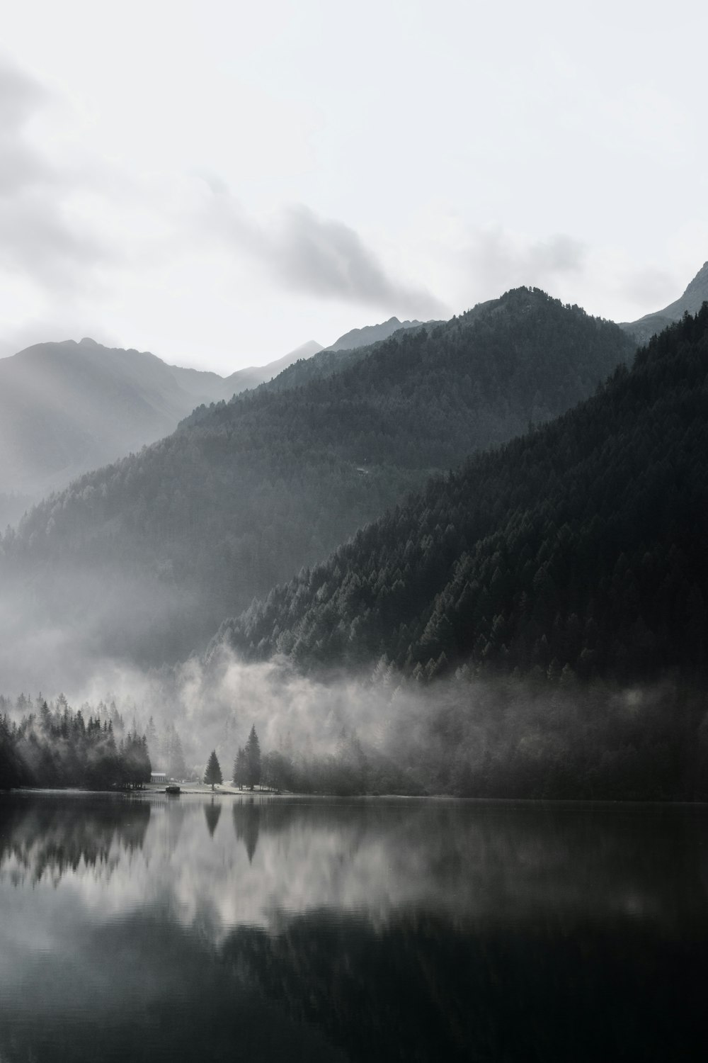 Photographie en niveaux de gris d’une chaîne de montagnes avec un plan d’eau